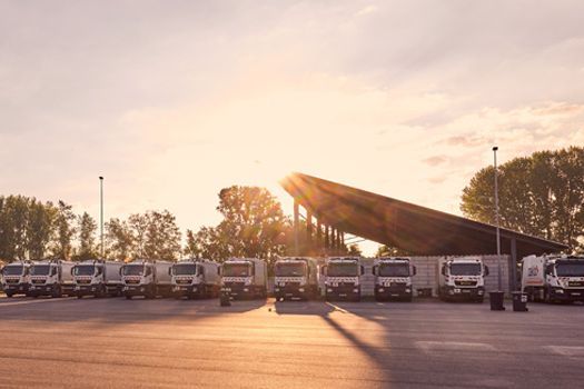 Parkende Müllautos im Sonnenaufgang